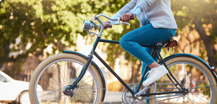 Persona che pedala su una bicicletta in un’area verde, simbolo di trasporto sostenibile.